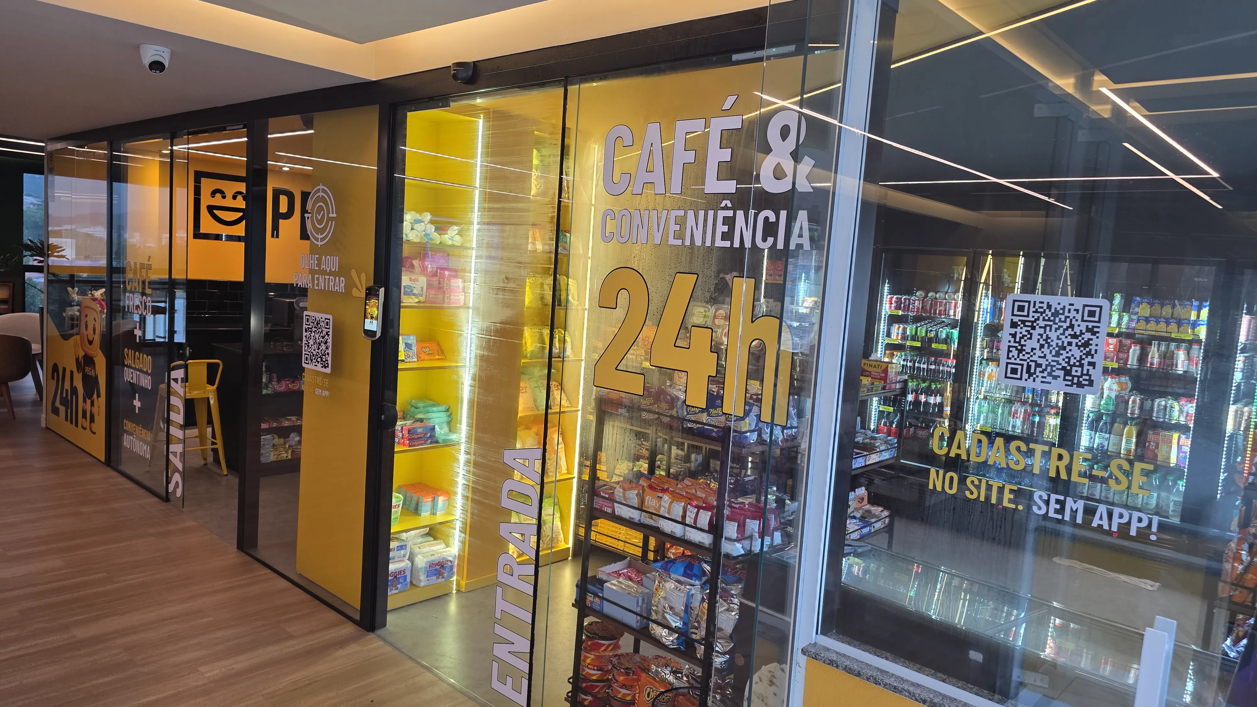 Vitrine PEG-AI no Hospital Jaraguá mostrando café e conveniência 24h, com prateleiras de produtos e sinalização de entrada